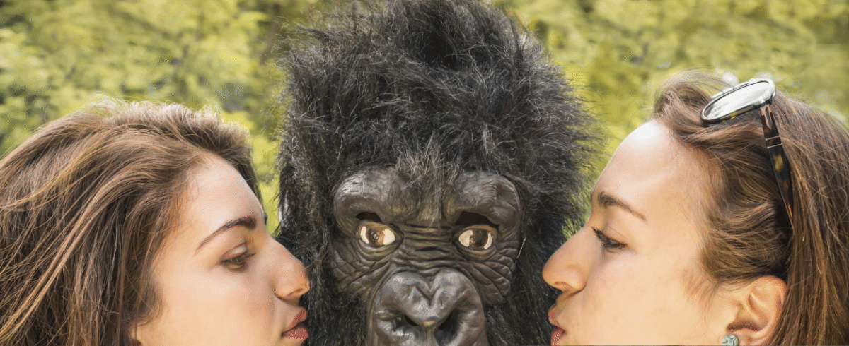 Female gorilla trekking guide leading tourists through lush forest
